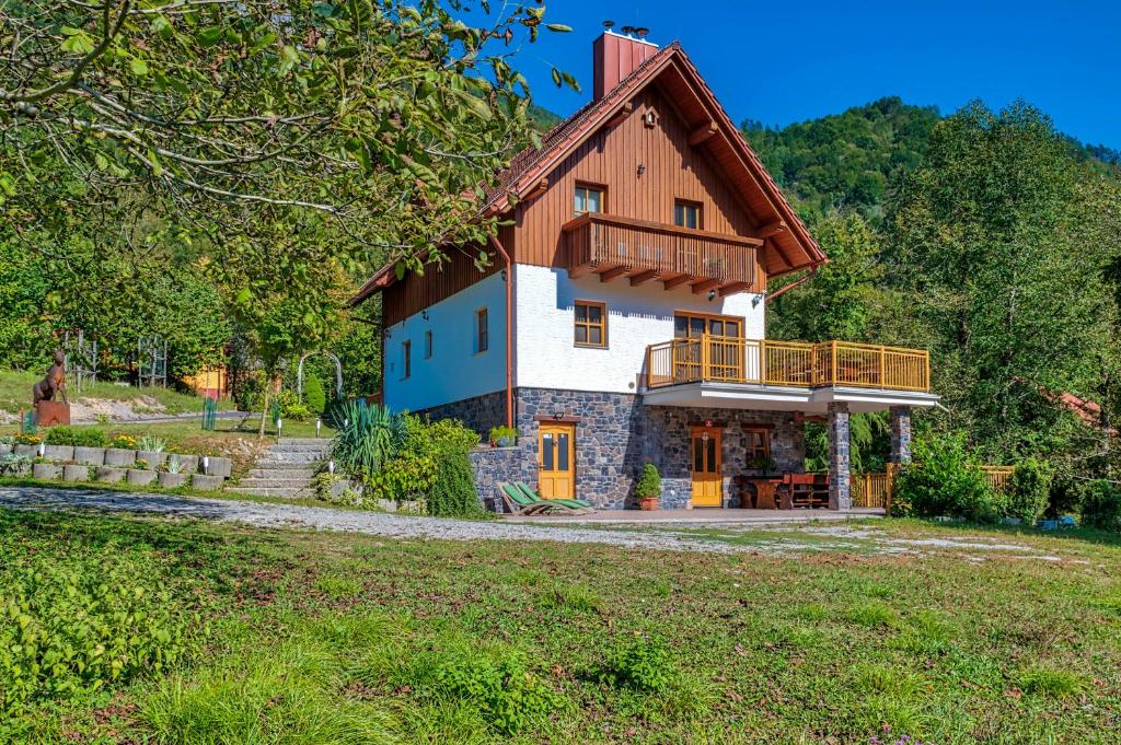 a large house with a balcony on top of it at Mountain house Rupicapra with Sauna and Outdoor Hot Tub in Kostel