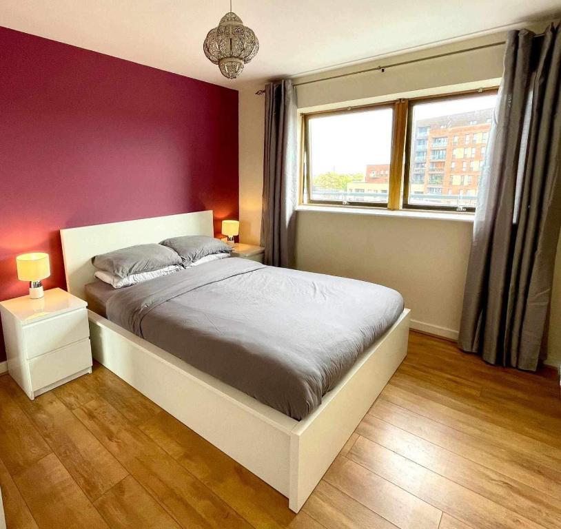 1 dormitorio con cama blanca y pared morada en One bedroom with Great city views, en Londres
