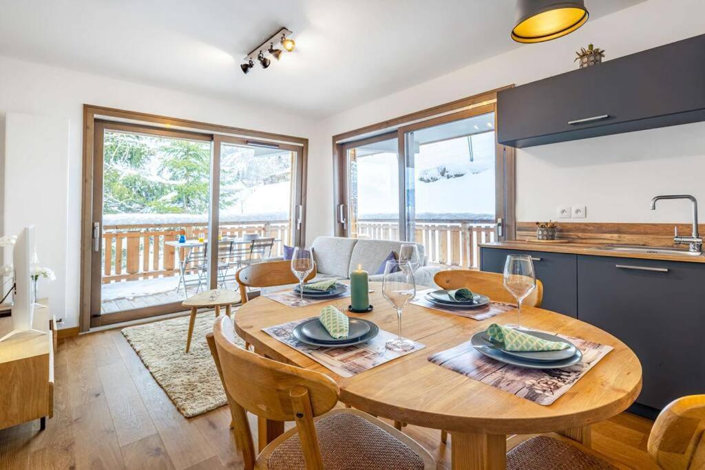 une cuisine et une salle à manger avec une table et des chaises en bois dans l'établissement Les Freinets - Apt D303 - BO Immobilier, à Châtel