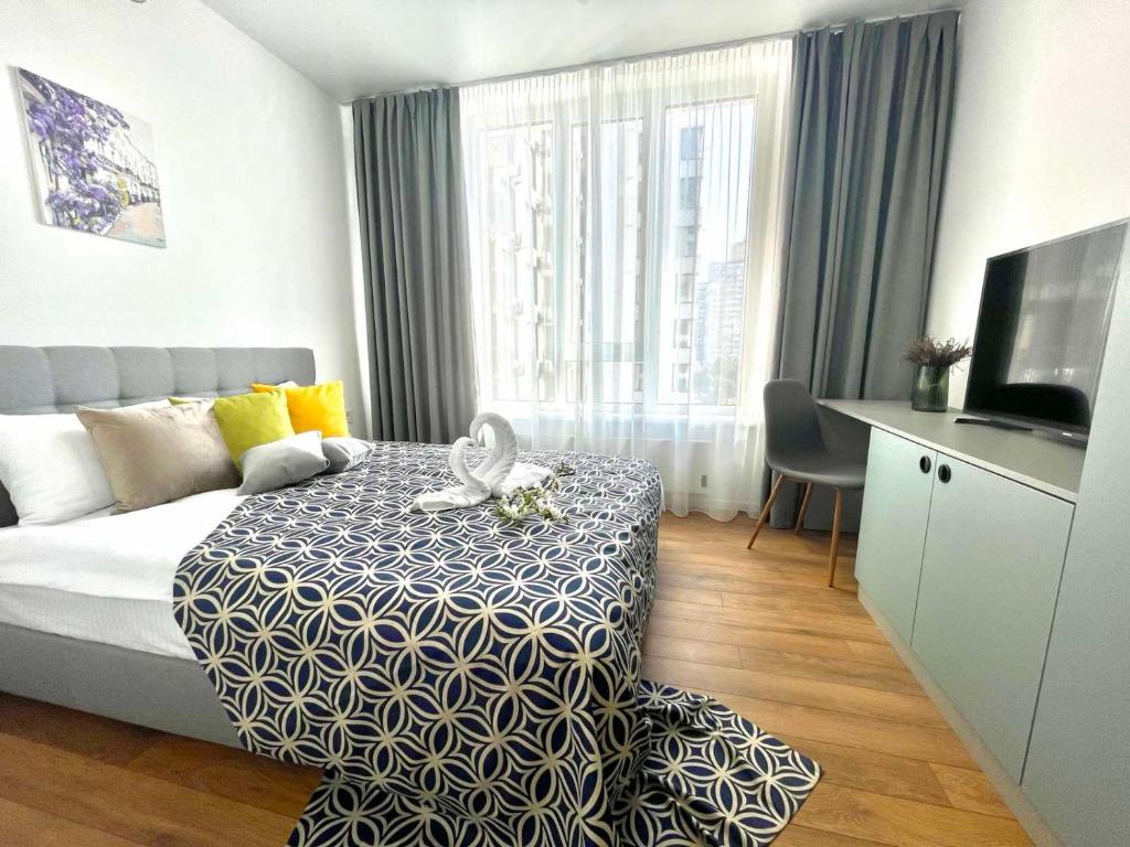 Habitación de hotel con cama, escritorio y TV. en Люкс апартаменти в затишному ЖК бізнес класу en Kiev