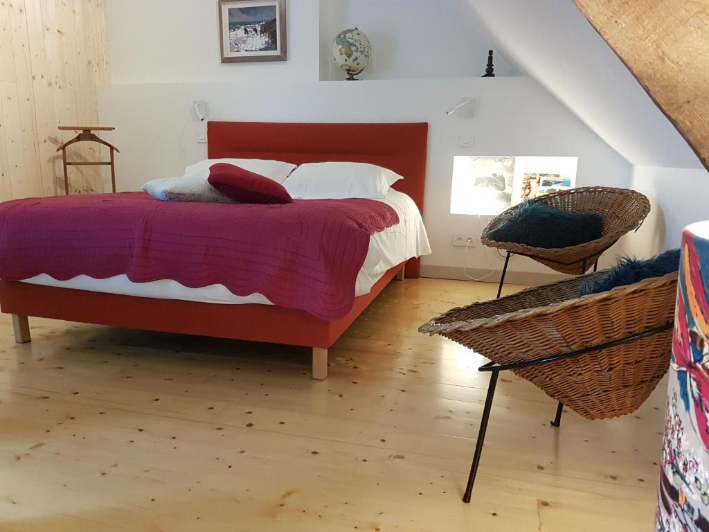 - une chambre avec un lit doté d'une tête de lit rouge dans l'établissement évasion entre mer et marais, à Batz-sur-Mer