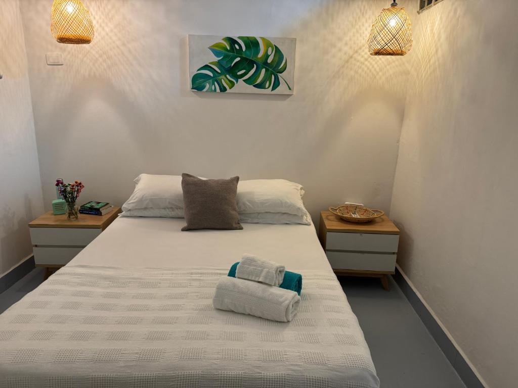 1 dormitorio con 1 cama con toallas en El Barrio Hostal en Cartagena de Indias