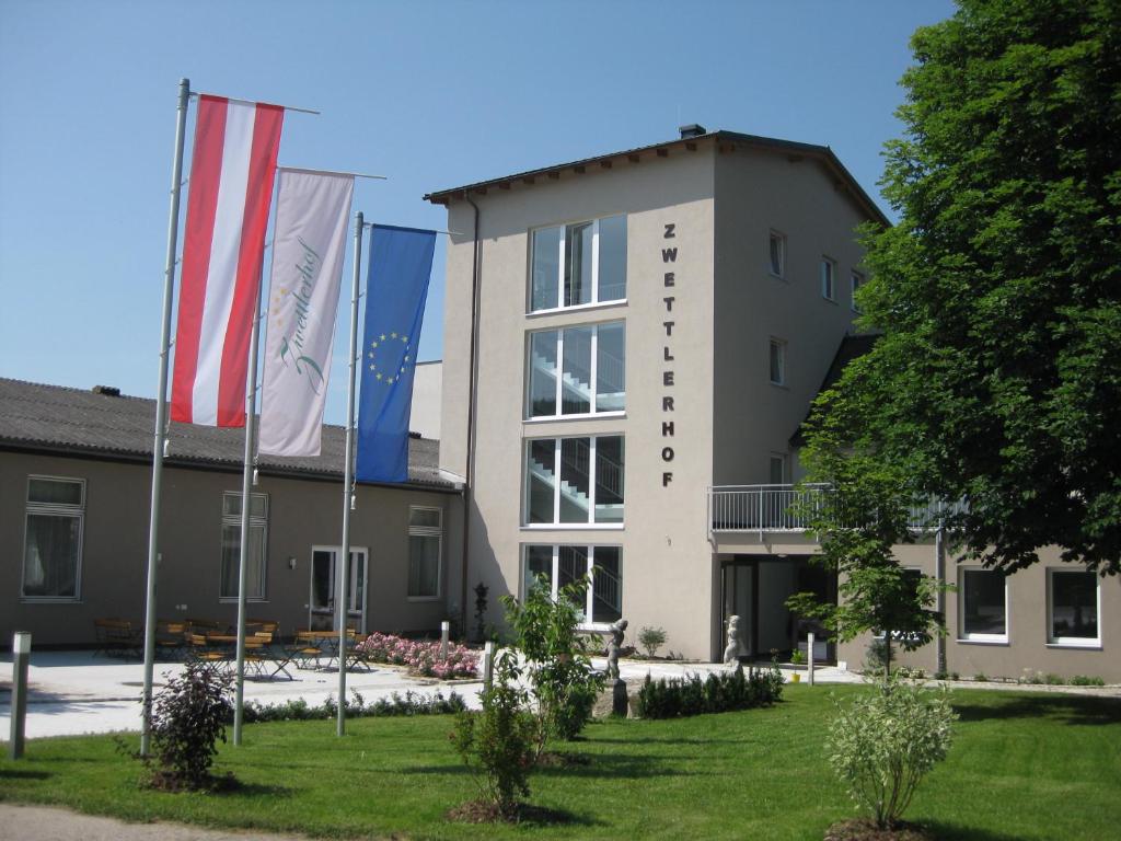 un edificio con tres banderas delante en Hotel Zwettlerhof, en Zwettl an der Rodl