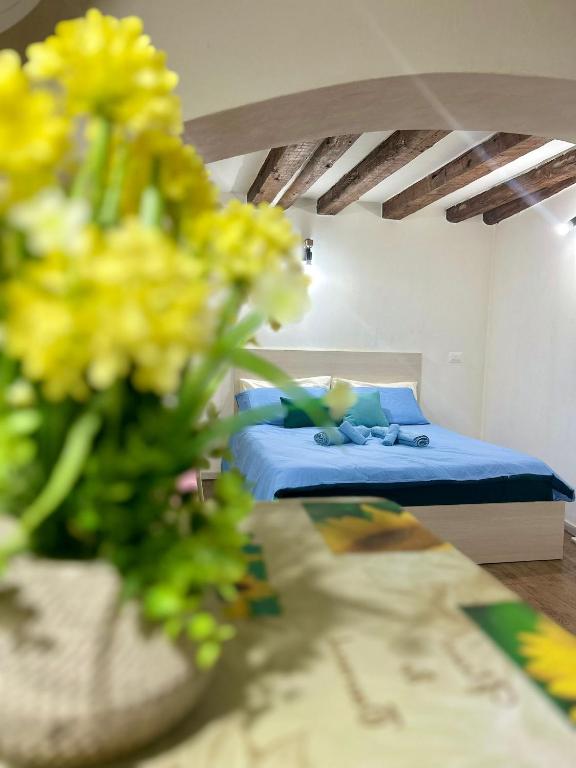 a bedroom with a bed and a vase with yellow flowers at RESIDENCE ZAR - 2 in Trieste
