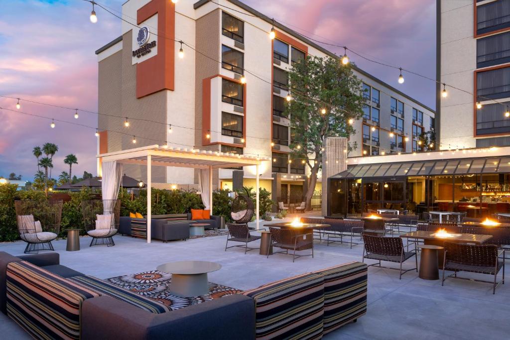 un patio con tavoli e sedie di fronte a un edificio di DoubleTree by Hilton San Bernardino a San Bernardino