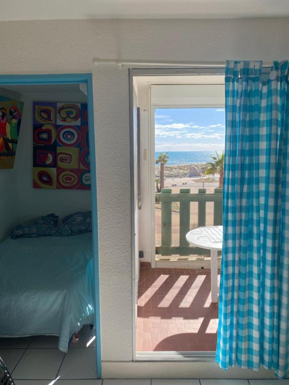 Schlafzimmer mit einer Tür, die auf eine Terrasse mit Aussicht führt in der Unterkunft T 2 cosy bord de mer in Le Barcarès