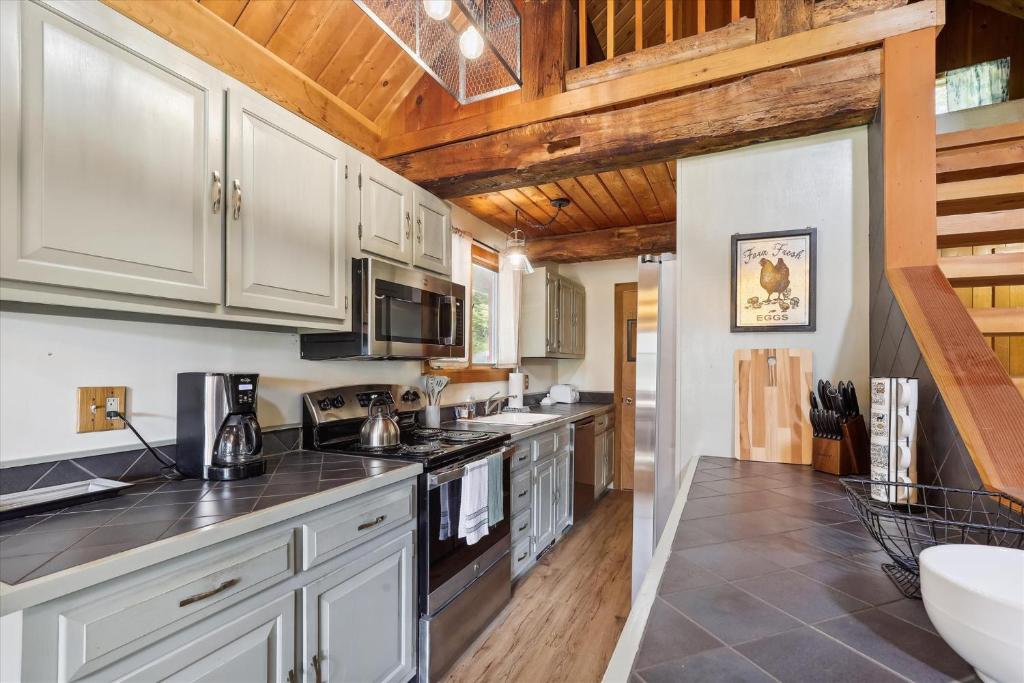 a kitchen with white appliances and wooden ceilings at Evergreen Chalet in Stowe