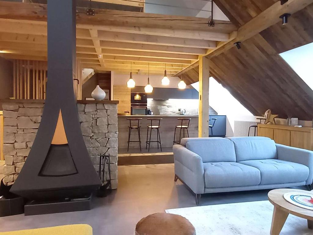 sala de estar con sofá azul y chimenea en Maison Villard-de-Lans, 5 pièces, 8 personnes - FR-1-548-26, en Villard-de-Lans