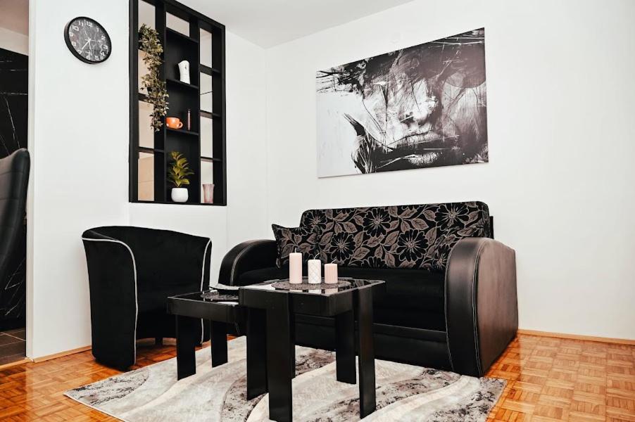 a living room with a couch and a table and chairs at M lux Kragujevac in Kragujevac