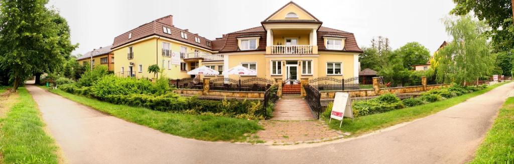 una gran casa amarilla al lado de una carretera en Willa Kolor, en Ustroń