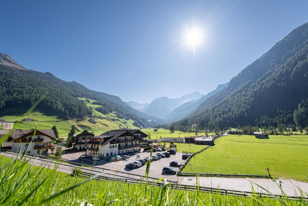 a view of a village in a valley with mountains at Hotel Bacher in Riva di Tures