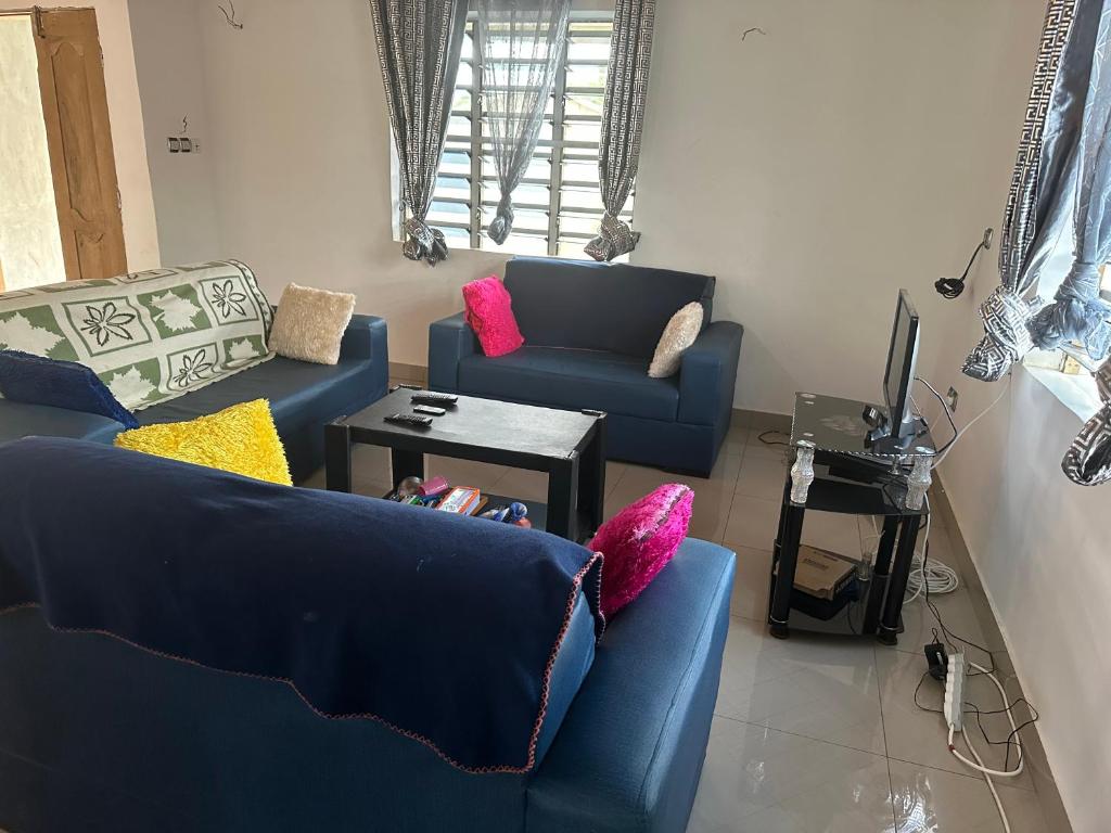 a living room with two blue couches and a table at Maison paisible abomey calavie in Cotonou