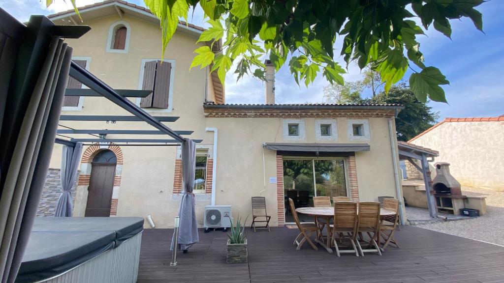 patio ze stołem i krzesłami przed domem w obiekcie Gites de Marchet w mieście Auvillar