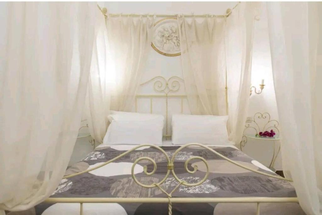 een slaapkamer met een hemelbed en witte gordijnen bij Ca Briani DX in Venetië