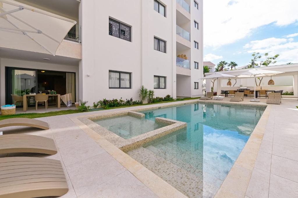 a swimming pool in front of a building at Fantastic brand new beach condo in Punta Cana