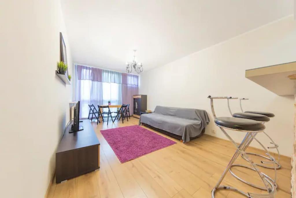 a bedroom with a bed and a table and a chair at Urbannestgroup - City Center - Pereca 2 in Warsaw