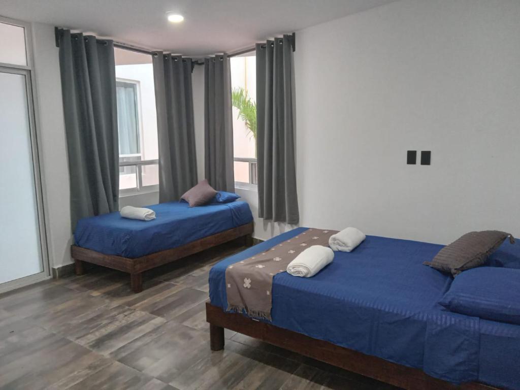 a bedroom with two beds and a window at Villas Carlota Cancún in Cancún