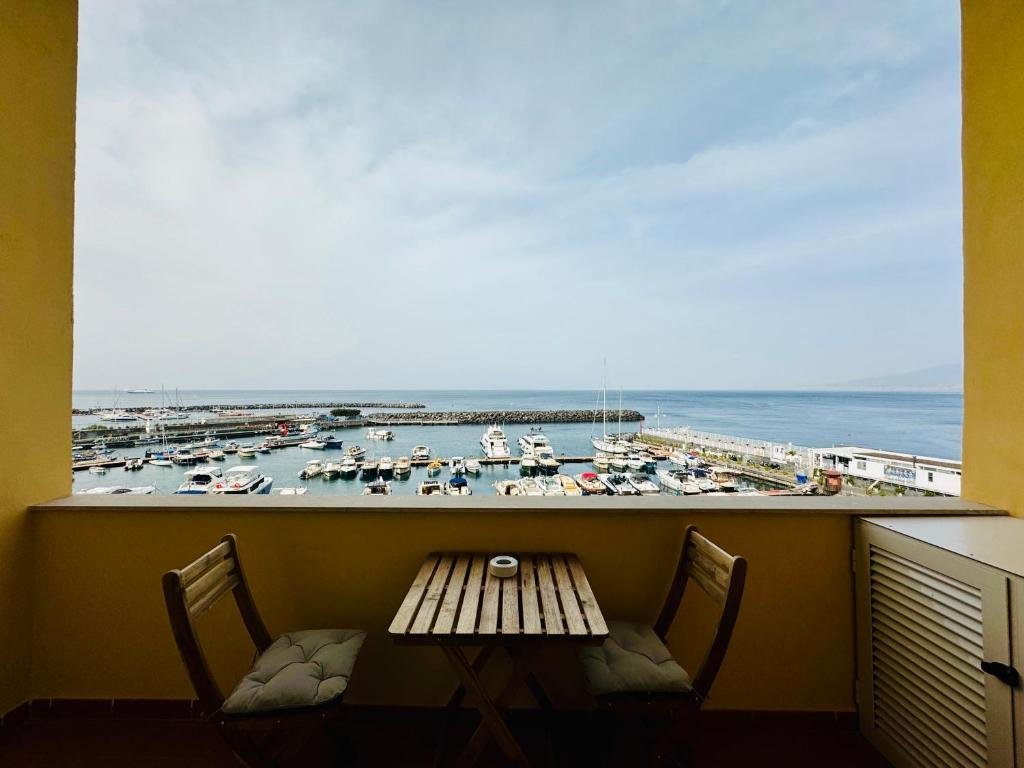 a balcony with a table and chairs and a view of a harbor at YourHome - Nettuno Apartments in Piano di Sorrento