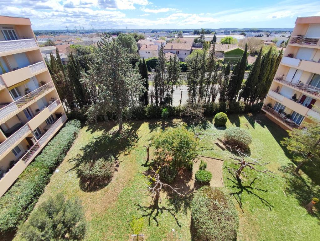 eine Luftansicht eines Gartens zwischen zwei Gebäuden in der Unterkunft Grand Appartement Ensoleillé avec Parking in Nîmes