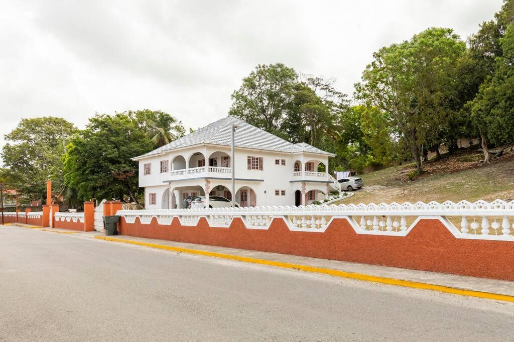 ein weißes Haus am Straßenrand in der Unterkunft Shaw Park Gem in Ocho Rios