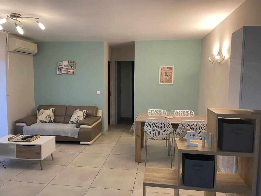 uma sala de estar com um sofá e uma mesa em Appartement calme, climatisé 3min à pied de la mer em Palavas-les-Flots