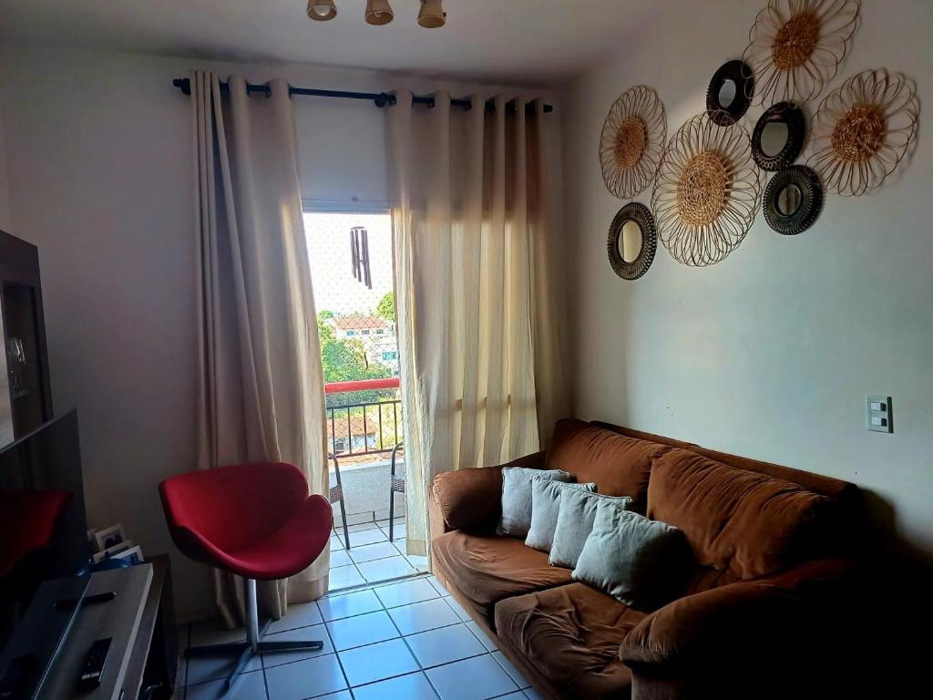 uma sala de estar com um sofá castanho e uma cadeira vermelha em Apartamento Compartilhado, com 02 Quartos, sendo 01 suíte em Manaus