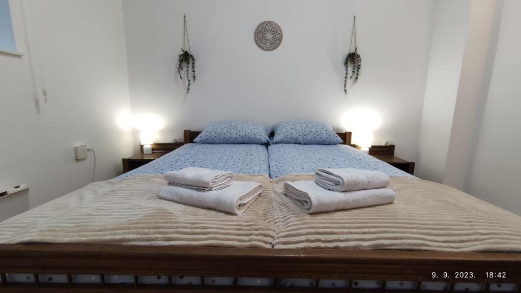 een slaapkamer met een bed met handdoeken erop bij Ski lift apartman dm Brzeće in Brzeće
