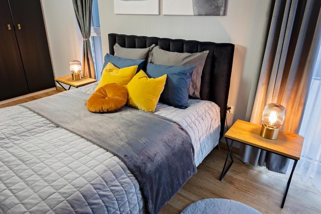 a bedroom with a bed with yellow and blue pillows at Apartamenty STUDIO in Busko-Zdrój