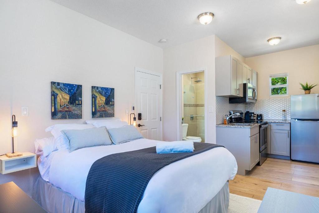 フォート・ローダーデールにあるAzure - Mins to Las Olas & Beachの白いベッドルーム(大型ベッド1台付)、キッチンが備わります。