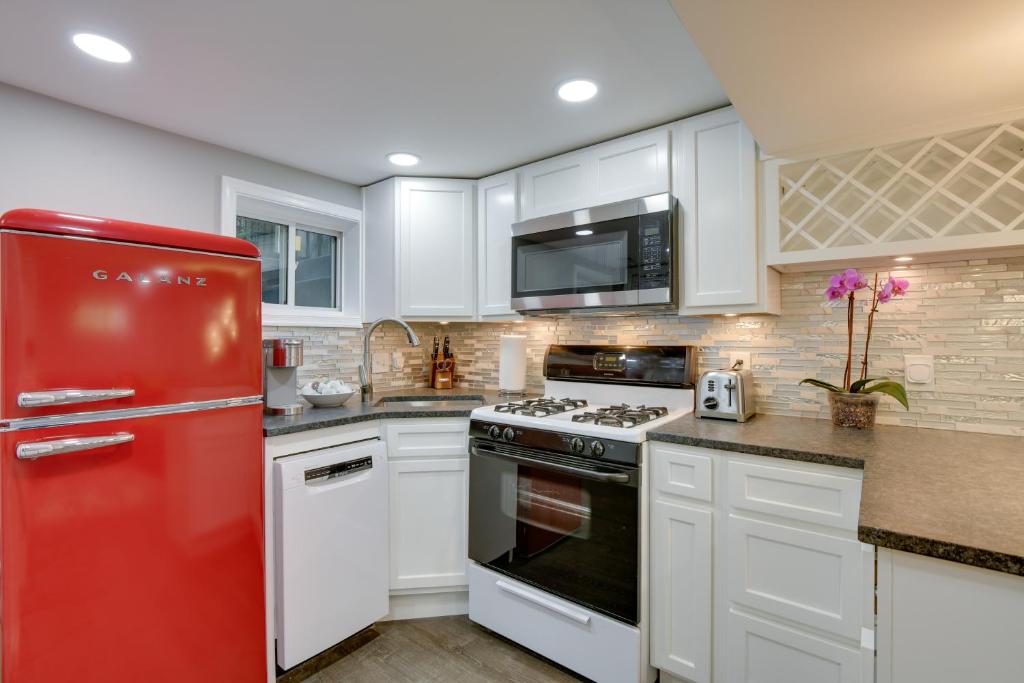 eine Küche mit einem roten Kühlschrank und weißen Schränken in der Unterkunft Convenient Washington, DC, Studio Near Metro Stop! in Washington