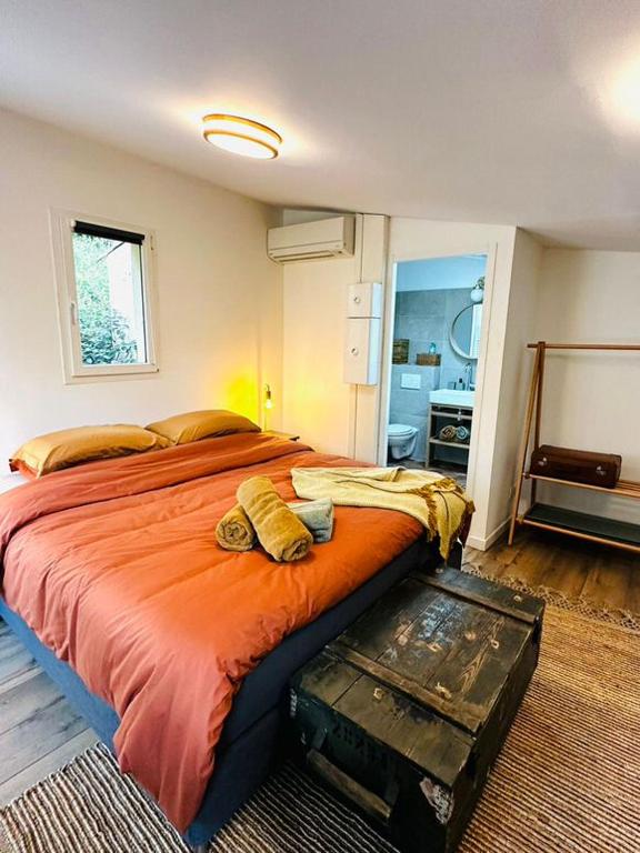 a bedroom with a large bed with an orange blanket at B&B Les Têtes de Mules - Adults Only in Gémenos