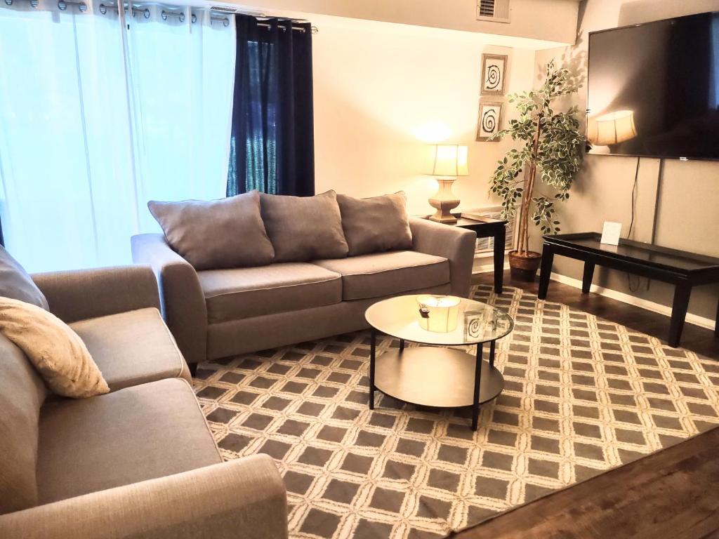 a living room with a couch and a table at Cozy Condo in Central Raleigh in Raleigh