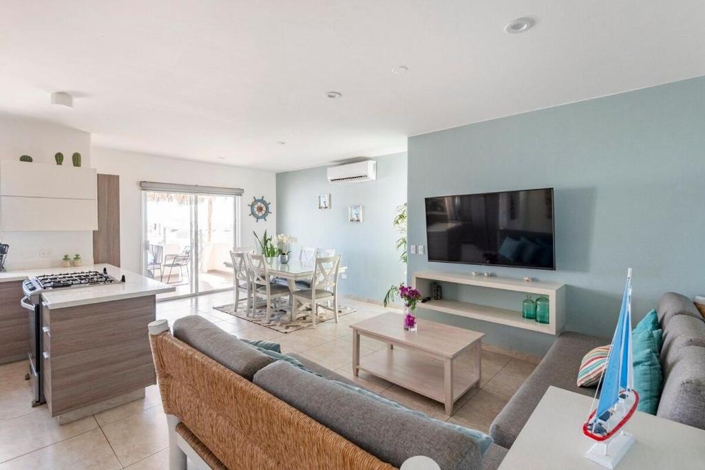 uma sala de estar com um sofá e uma televisão em Villa Alberca Privada 10 pax em Cabo San Lucas