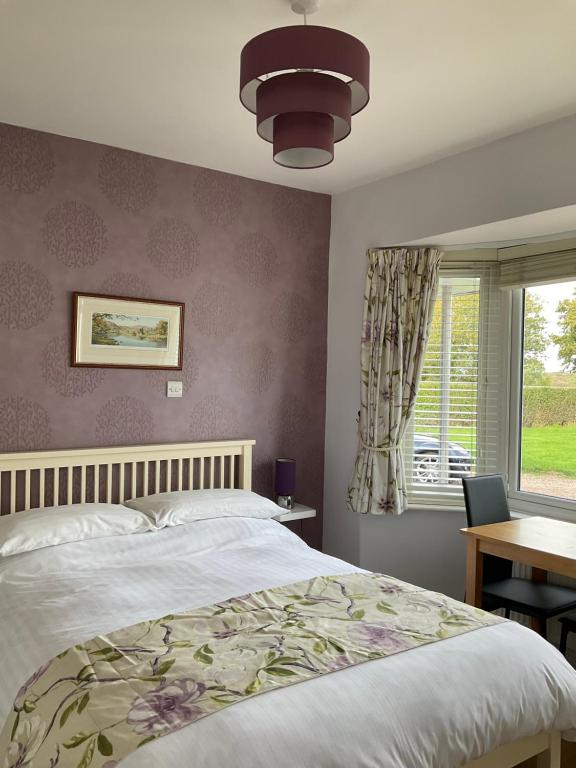 a bedroom with a large bed and a window at Wilmcote Bed and Breakfast in Wilmcote