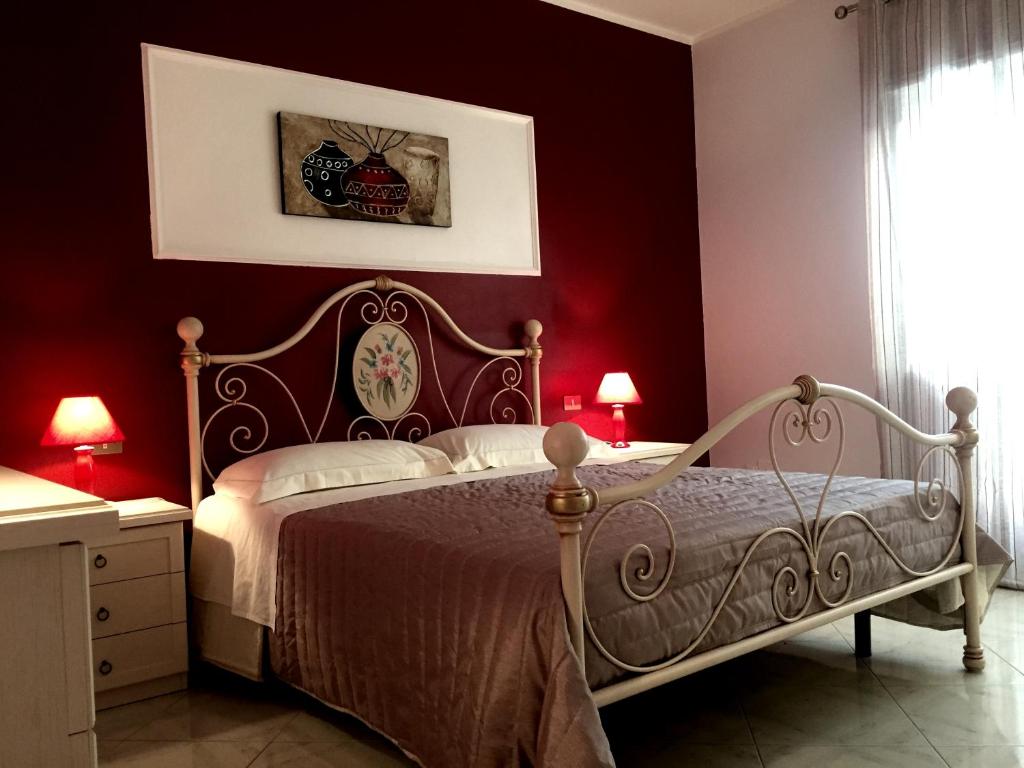BolognettaにあるMastro Toto' - Rooms & Apartmentの赤い壁のベッドルーム1室(ベッド1台付)