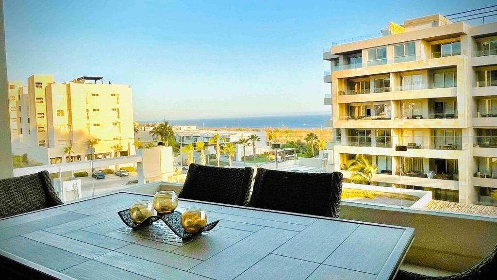 a table on a balcony with a view of the ocean at CONDO VISTA AL MAR ZONA TEZAL in Cabo San Lucas