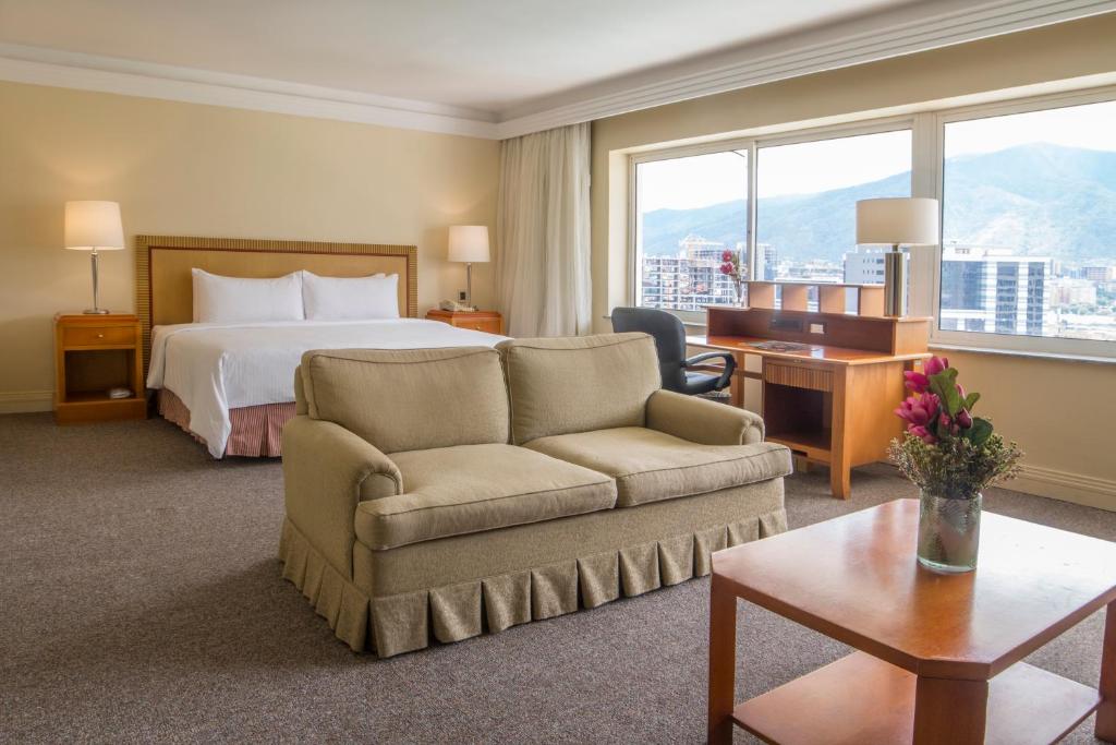 カラカスにあるHotel Tamanaco Caracasのベッドとソファ付きのホテルルーム