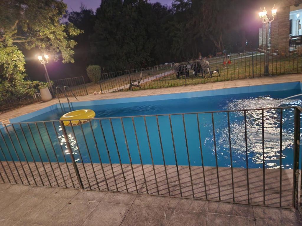 a fence around a swimming pool at night at LOS OLIVARES. SAN LORENZO in Salta