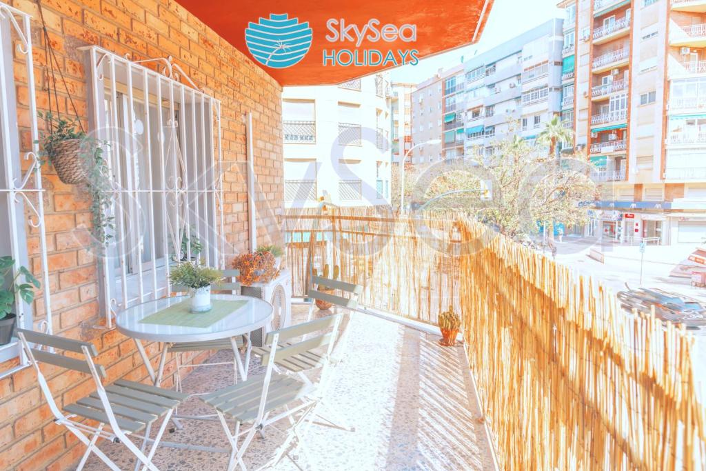 a patio with a table and chairs on a brick wall at SkySea Holidays MALAGA BAILEN in Málaga