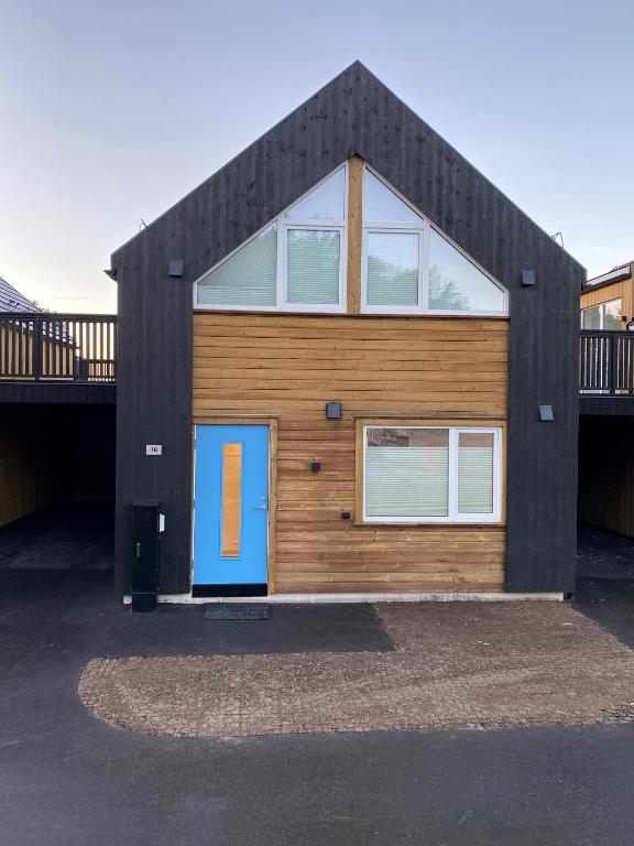 a house with a blue door on the front of it at Hytte på sørlandet in Kristiansand