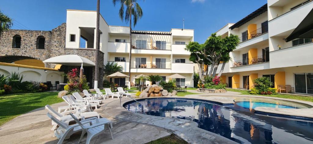 un complexe avec une piscine, des chaises et un bâtiment dans l'établissement Casa Francisco, à Cuernavaca