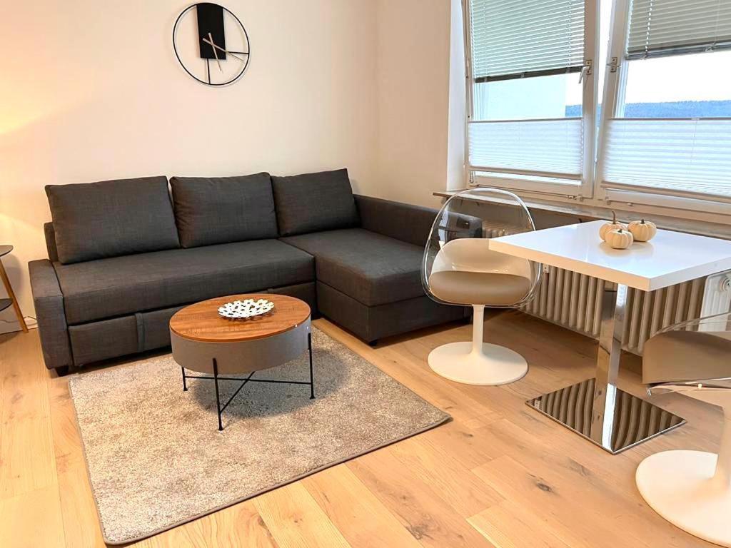a living room with a black couch and a table at Neue, attraktive Wohlfühlwohnung mit traumhafter Aussicht in Neubulach