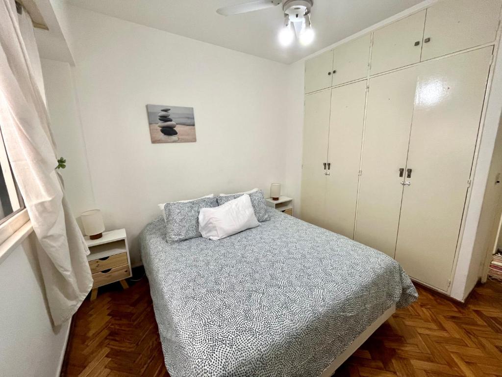 Dormitorio pequeño con cama y armarios blancos en Bulnes Apartment en Buenos Aires