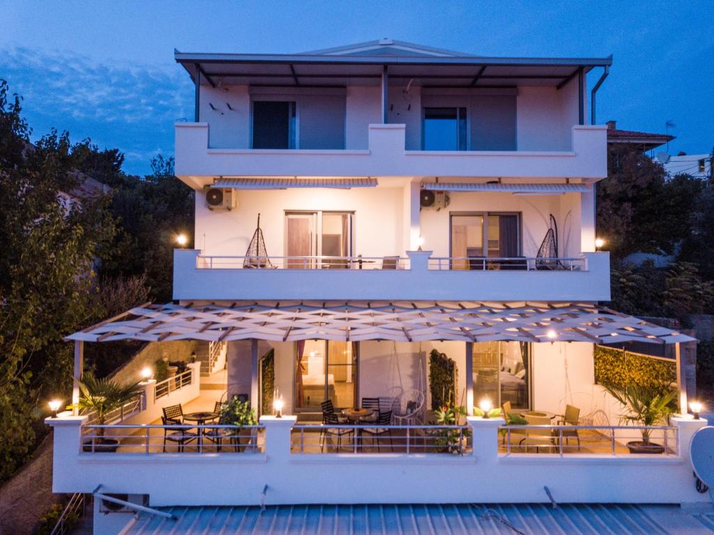 a large white house with a balcony at night at Apartments Bogojevic in Ulcinj