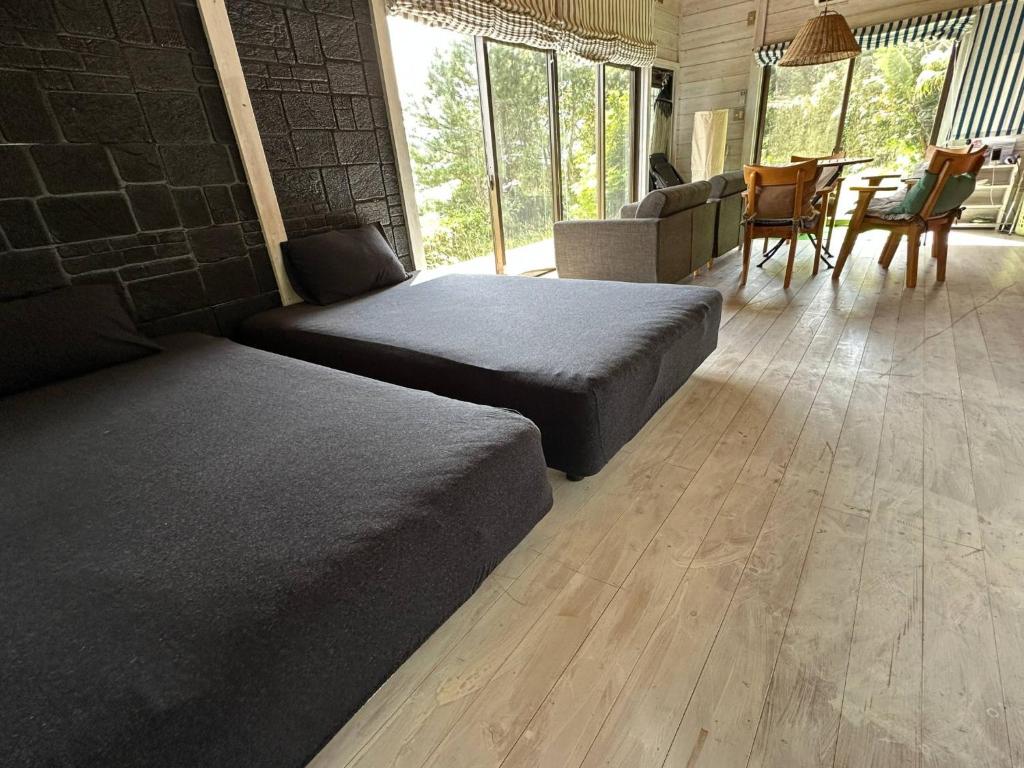 a bedroom with two beds and a table and chairs at Tiny Camp House Kurage - Vacation STAY 66334v in Kamijinoo
