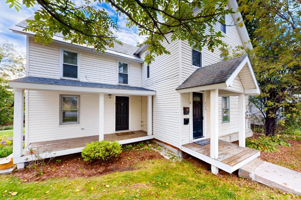 une maison blanche avec une terrasse couverte et une cour dans l'établissement Vermont Marble Haven - Unit 2, à Rutland