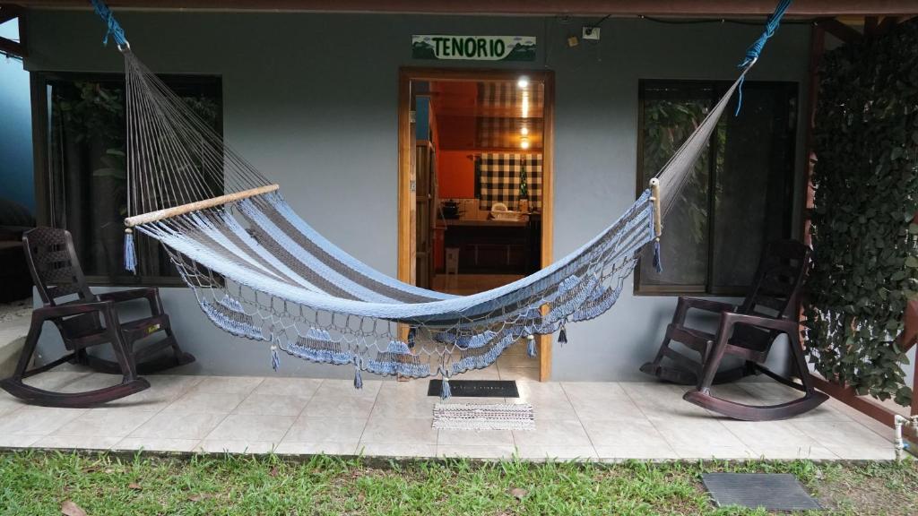 una hamaca en la parte delantera de una casa en TENORIO - Rio Celeste Dreams en Bijagua