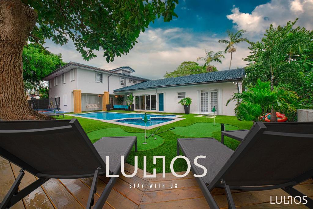 a house with a swimming pool and two chairs at Grand Home Jacuzzi, Heated Pool, Games, BB Court L20 in Miami