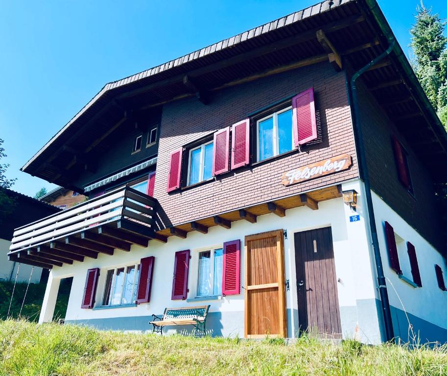 una casa con ventanas coloridas y un banco en una colina en Felsenberg - CharmingStay, en Flumserberg