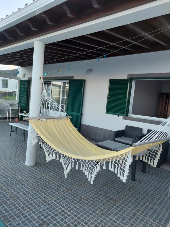 a hammock on the back porch of a house at Casa da Adega in Ribeira Chã
